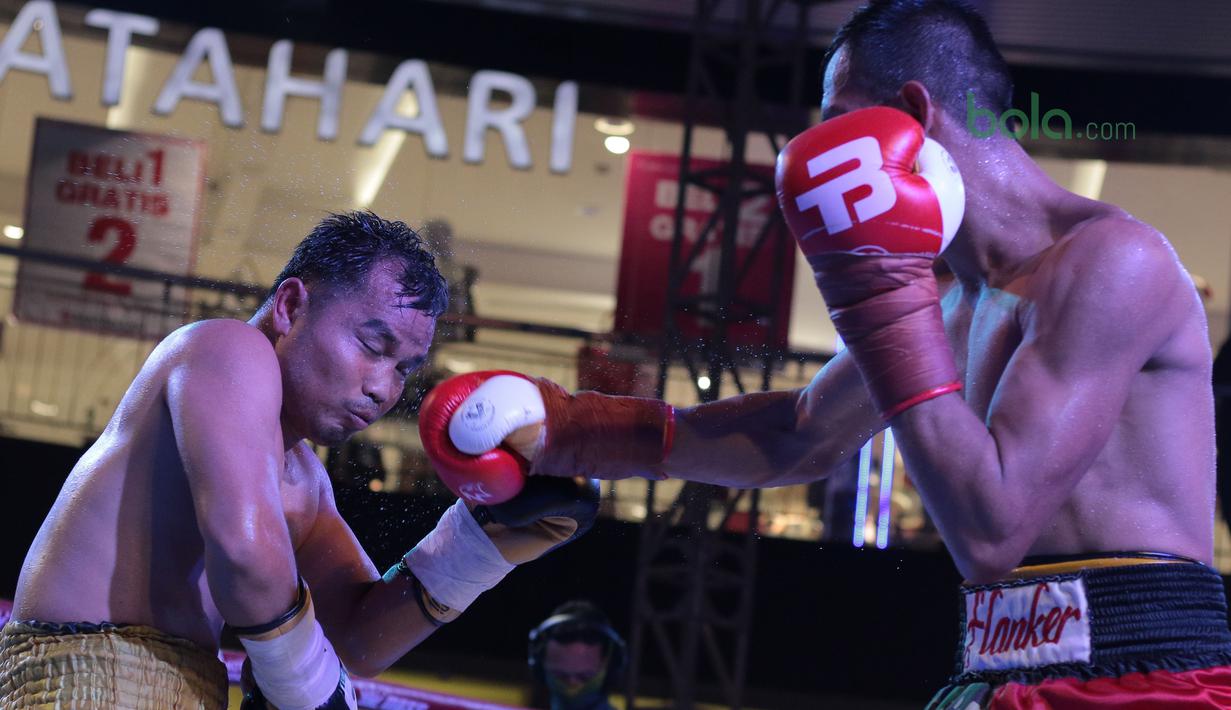 Aksi Ilham Leoisa (kanan) melepaskan hook ke wajah petinju Thailand, Paiboon Lorkham pada kelas Super-Lightweight Mahkota Boxing Super Series di Cilandak Town Square, Jakarta (10/3/2018). Ilham menang angka mutlak. (Bola.com/Nick Hanoatubun)