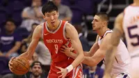 Pebasket Houston Rockets, Zhou Qi, berusaha melewati pebasket Phoenix Suns pada laga NBA di Arizona, AS, Minggu (16/11/2017). (AFP/Christian Petersen)