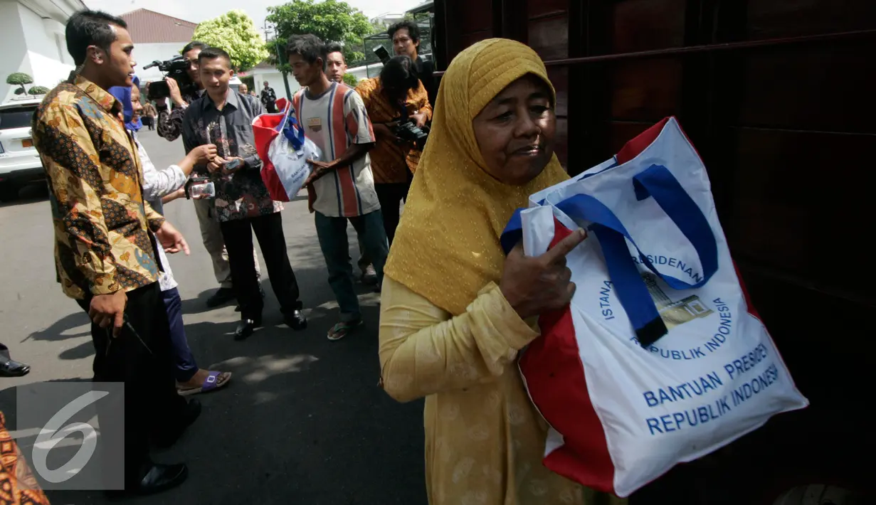 Warga membawa semboko dari Presiden Jokowi saat open house di Istana Kepresidenan Gedung Agung, Yogyakarta, Sabtu (9/7). Open House ini diikuti oleh ribuan masyarakat yang berada di Yogyakarta. (Liputan6.com/Boy Harjanto)