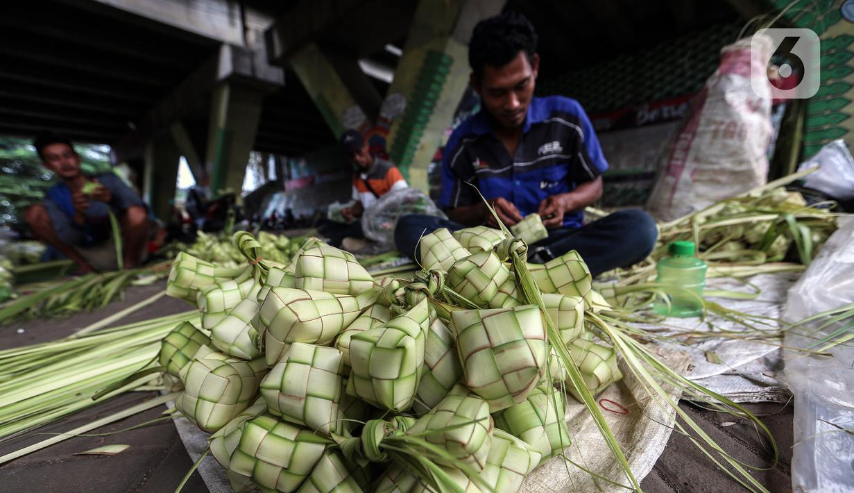Perajin membuat kulit ketupat dari janur saat berdagang di Pesanggrahan, Jakarta, Kamis (20/4/2023). (Liputan6.com/Johan Tallo)