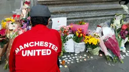 Seorang pria meletakan bunga di Albert Square, Manchester, Inggris, (23/5). Ribuan warga menunjukkan solidaritas terhadap korban bom di konser Ariana Grande dengan berdoa bersama serta meletakan bunga dan lilin. (AP Photo/Kirsty Wigglesworth)