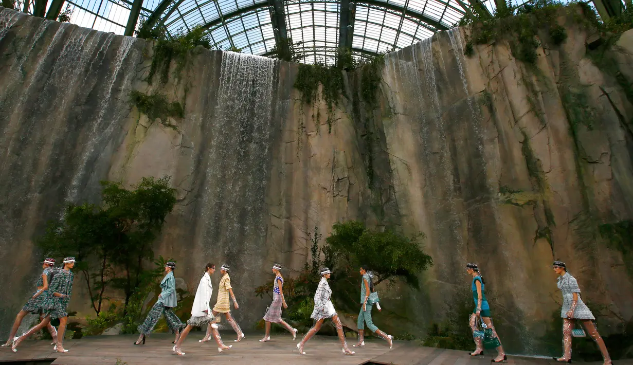 Para model berjalan di catwalk memamerkan koleksi Spring/Summer 2018 untuk Chanel selama Paris Fashion Week, Selasa (3/10). Menutup pekan mode itu, desainer Karl Lagerfeld mengubah interior ruangan Grand Palais menjadi nuansa alam (AP Photo/Francois Mori)