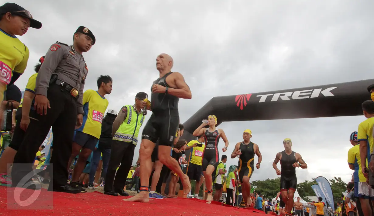 Peserta memasuki trek berlari saat mengikuti Herbalife Bali International Triathlon 2016 di Sanur, Bali, Minggu (14/8). Sebanyak 1754 peserta dari 26 negara, ikut dalam lomba tersebut. (Liputan6.com/Made Anto)