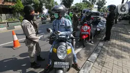 Petugas memeriksa identitas pengendara bermotor pada hari pertama PSBB di jalur check point Jalan Ir. H Juanda, Ciputat, Tangerang Selatan, Sabtu (18/4/2020). Selama PSBB pengendara motor wajib kenakan master dan tidak boleh berboncengan kecuali suami istri. (Liputan6.com/Fery Pradolo)