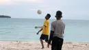 Seorang pemuda melakukan kontrol bola saat bermain bola dekat pantai di Desa Matwaer, Kei Kecil, Maluku (25/12/2017). Bermain bola di pasir menjadi daya tarik tersendiri bagi anak-anak dan pemuda desa. (Bola.com/Nick Hanoatubun)