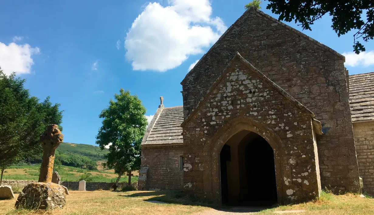 Gereja St Mary di Tyneham berdiri di bawah langit biru yang cerah pada 8 Juli 2018. Tyneham dijuluki sebagai 'desa hantu.'  (AP Photo/Jerry Harmer)