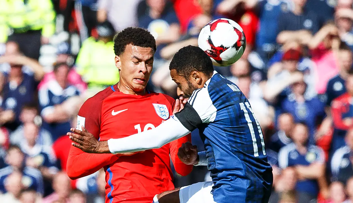 Gelandang Inggris, Dele Alli, berebut bola dengan bek  Skotlandia, Ikechi Anya  pada kualifikasi Piala Dunia 2018 di Hampden Park, Sabtu (10/6/2017). Skor berakhir imbang 2-2. (EPA/Robert Perry)