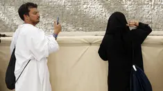 Seorang jemaah haji mengabadikan istrinya saat melempar batu melaksanakan lempar jumrah di Mina, dekat kota suci Makkah, Arab Saudi (11/8/2019). Usai wukuf di Padang Arafah, jutaan jemaah haji melanjutkan lempar jumrah yang merupakan simbol perlawanan terhadap setan. (AP Photo/Amr Nabil)