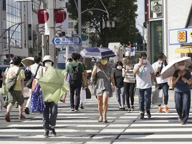 Orang-orang yang memakai masker untuk membantu mengekang penyebaran virus corona COVID-19 berjalan di jalan di Tokyo, Jepang, Jumat (6/8/2021). Tokyo berada dalam keadaan darurat virus corona COVID-19 sejak pertengahan Juli. (AP Photo/Kantaro Komiya)