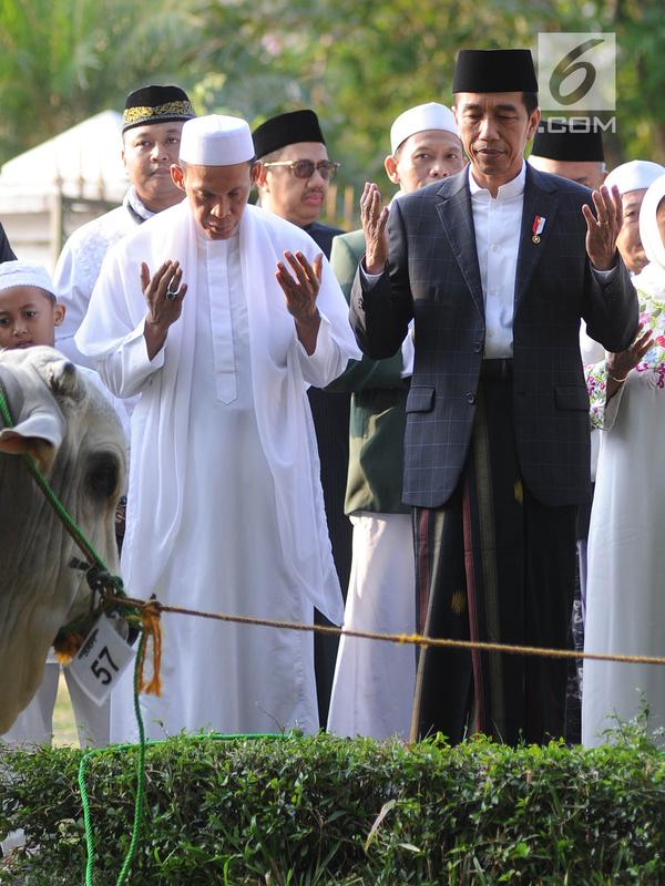 Presiden Joko Widodo atau Jokowi memanjatkan doa saat menyerahkan sapi braman 1,4 ton kepada DKM Baitul Faizin usai salat Idul Adha 1439 Hijriah di Lapangan Tegar Beriman, Cibinong, Kabupaten Bogor, Jawa Barat, Rabu (22/08). (Merdeka.com/Arie Basuki)