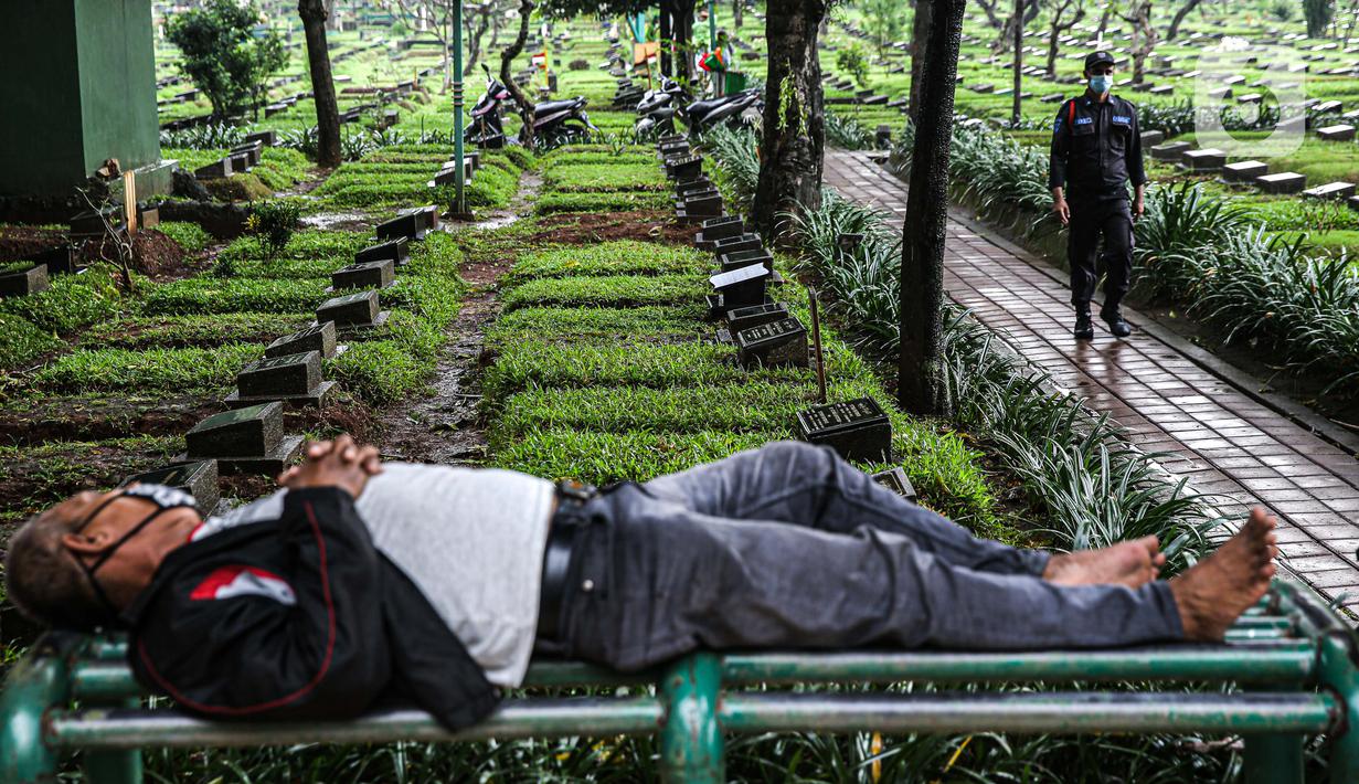 Petugas keamanan berjalan di Tempat Pemakaman Umum (TPU) Karet Bivak, Jakarta, Minggu (27/6/2021). Pemerintah Provinsi DKI Jakarta membatasi aktivitas dan kunjungan ke TPU hingga 5 Juli 2021 untuk menekan penularan COVID-19. (Liputan6.com/Faizal Fanani)