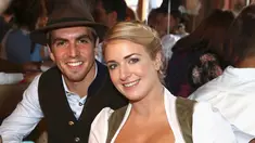Kapten Bayern Munchen, Philipp Lahm bersama istrinya Claudia tersenyum saat menghadiri acara Oktoberfest di Munich, Jerman (2/9). (REUTERS/Alexander Hassenstein)