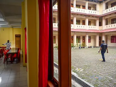 Seorang anggota Badan Penanggulangan Bencana Daerah (BPBD) menyemprotkan disinfektan di dalam ruang makan sebuah Sekolah Menengah Pertama (SMP) dalam rangka program mitigasi pencegahan penyebaran flu burung di Banda Aceh pada Jumat 31 Oktober 2025. Tim dari Badan Penanggulangan Bencana Daerah (BPBD) Kota Banda Aceh melakukan penyemprotan disinfektan ke beberapa sekolah menengah. (Chaideer MAHYUDDIN/AFP)