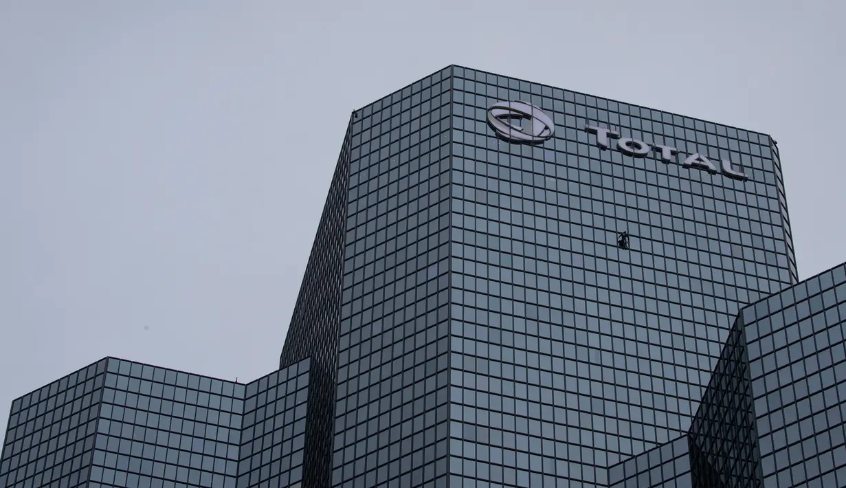 Pendaki Alain Robert atau French Spiderman memanjat Menara Total di kawasan bisnis La Defense, Paris, Prancis, Senin (13/1/2020). Alain memanjat gedung tersebut tanpa menggunakan tali pengaman. (Thomas SAMSON/AFP)