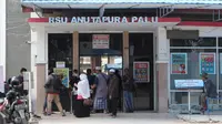 sejumlah warga penjenguk pasien saat memasuki pintu utama Rumah Sakit Anutapura Palu. Rumah sakit daerah tersebut menjadi salah satu rumah sakit rujukan penanganan Covid-19 sejak Maret 2020 lalu. (Foto:Liputan6.com/ Heri Susanto).