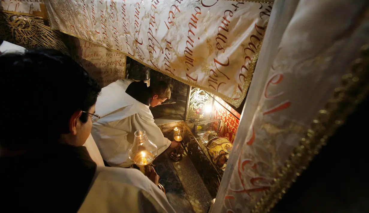 Pendeta menghadiri Misa Natal tengah malam di Gereja Kelahiran di kota Bethlehem, Palestina (25/12). (Mussa Qawasma / Pool Photo via AP)