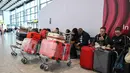 Pihak maskapai menjelaskan bahwa keputusan pembatalan dilakukan sebagai bentuk penerapan standar keamanan dan keselamatan penerbangan. Tampak dalam foto, para penumpang duduk menunggu kabar tentang penerbangan di Terminal 4 Bandara Heathrow, London pada Minggu 1 Maret 2026. (JUSTIN TALLIS/AFP)