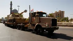 Pasukan keamanan Irak membawa sebuah tank saat mengambil bagian dalam parade militer di sepanjang jalan Kota Baghdad, Irak (12/7). Irak memamerkan kekuatan peralatan tempur unggulannya sebagai langkah lanjutan menggempur ISIS. (REUTERS/Khalid al Mousily)