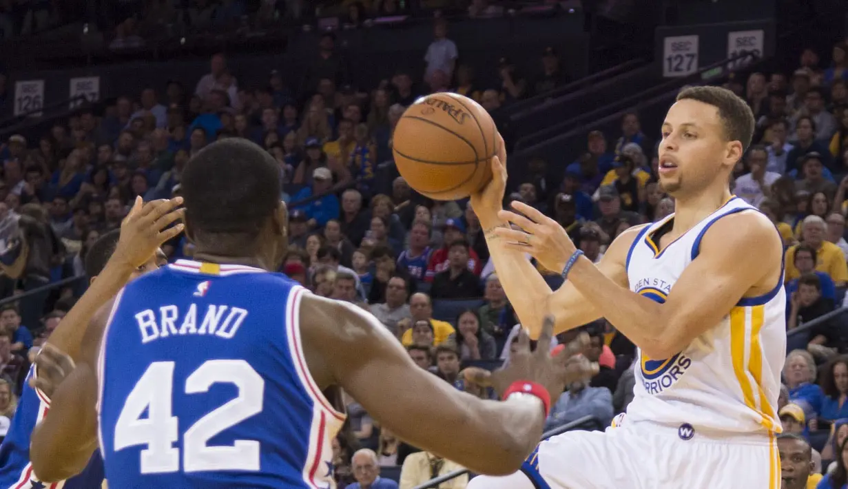 Guard Golden State Warriors, Stephen Curry (kaan) mencoba melewati hadangan pemain Philadelphia 76ers pada lanjutan NBA di Oracle Arena, Minggu (27/3/2016). Warriors menang atas 76ers 117-105. (Mandatory Credit: Kyle Terada-USA TODAY Sports)