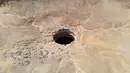 Pemandangan udara yang diambil pada 6 Juni 2021 menunjukkan Sumur Barhout yang dikenal sebagai Sumur Neraka di gurun Provinsi Al-Mahra Yaman. Sumur Neraka lebih dekat ke perbatasan dengan Oman daripada ke Ibu Kota Sanaa yang berjarak 1.300 kilometer (800 mil). (AFP)