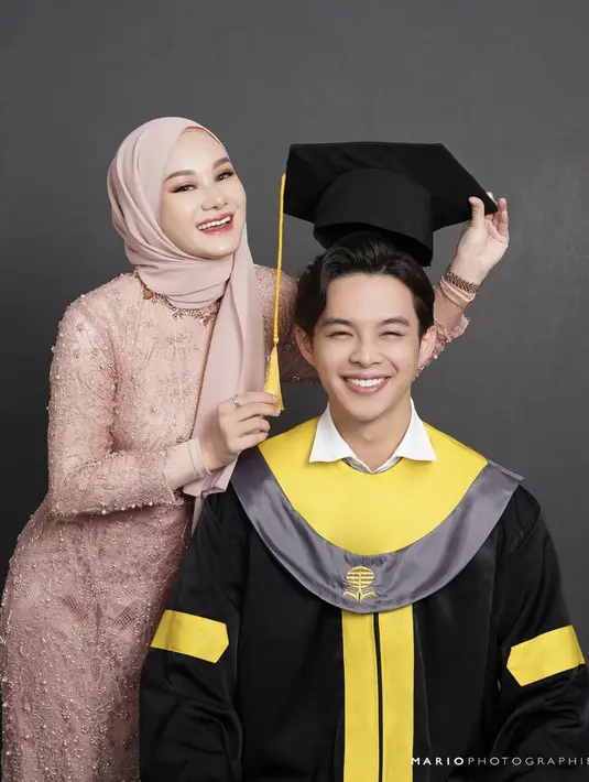 Rey pun mengenakan kemeja putih di atas toganya, dipadukan celana hitam serasi dengan sepatunya. [Instagram/@mariophotographie]