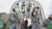 Para pengunjung berjalan melewati terowongan yang terbuat dari tas-tas plastik di depan istana kepresidenan La Moneda di Santiago, dalam perayaan Hari Lingkungan Hidup Dunia, 5 Juni 2018. (AFP)