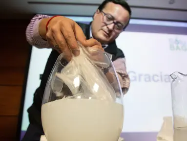 Insinyur Chile, Christian Olivares melarutkan tas plastik bermaterial biodegradable ke dalam air di Santiago, Selasa (24/7). Tas inovatif tersebut bisa menjadi pengganti plastik-plastik yang selama ini mencemari lingkungan. (AFP/CLAUDIO REYES)