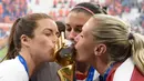 Para pemain Amerika Serikat mencium piala merayakan gelar juara Piala Dunia Wanita 2019 usai mengalahkan Belanda pada laga final di Stadion Lyon, Lyon, Minggu (7/7). AS menang 2-0 atas Belanda. (AFP/Phillippe Desmazes)