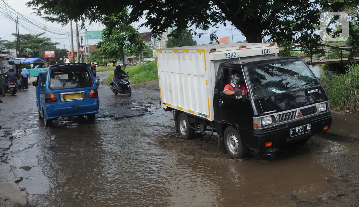 Kendaraan menghindari lubang yang cukup dalam akibat jalan yang rusak di Jalan Raya Bojonggede, Bogor Senin (11/5/2020). Beberapa titik jalan yang menghubungkan Citayam Depok - Bojonggede Bogor mengalami kerusakan yang cukup parah sejak tiga bulan terakhir. (merdeka.com/Arie Basuki)
