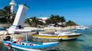 Dua kapal bersandar di pantai di Puerto Morelos, negara bagian Quintana Roo, Meksiko (14/2). Puerto Morelos bergabung dengan desa Leona Vicario pada 6 Desember 2015, untuk menjadi kota ke-11 di Quintana Roo. (AFP Photo/Daniel Slim)