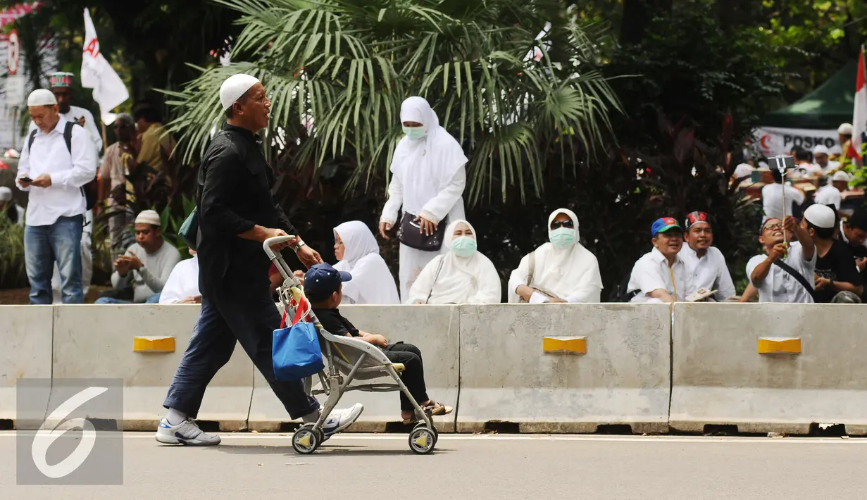Massa aksi mendorong anak melintasi Jalan Merdeka Barat, Jakarta, Jumat (4/11). Massa melakukan aksi di depan Istana Negara menuntut penegakan hukum kasus dugaan penistaan agama. (Liputan6.com/Helmi Fithriansyah)