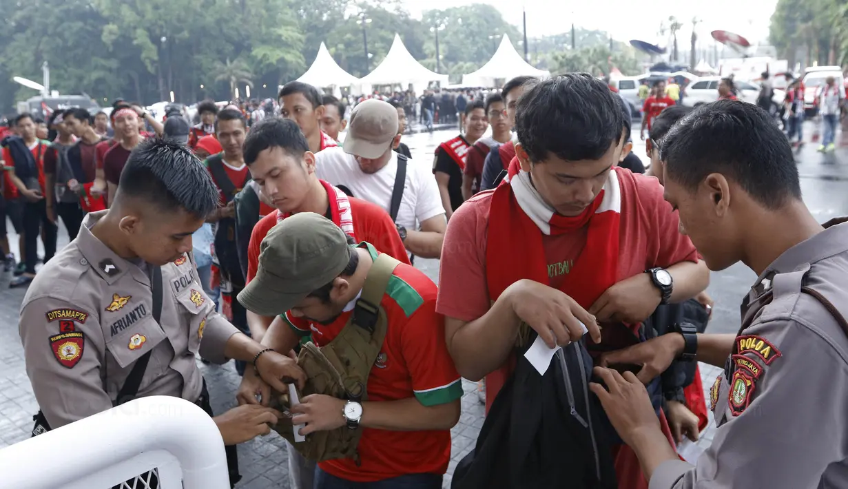 Polisi memeriksa suporter sebelum memasuki SUGBK, Senayan, Jakarta, Minggu (14/1/2018). Fasilitas baru tersebut untuk meningkatkan keamananan, kenyamanan serta kedisiplinan suporter. (Bola.com/M Iqbal Ichsan)