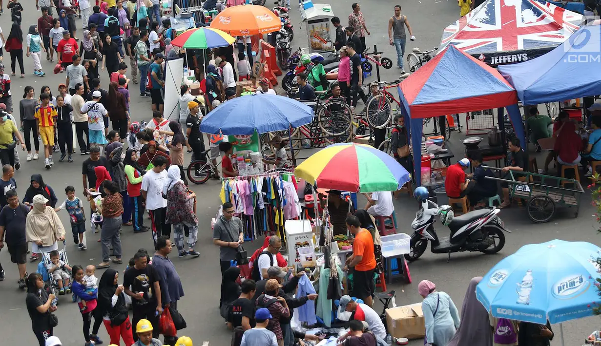 Pedagang kaki lima (PKL) berjualan di sepanjang Jalan Sudirman saat pelaksanaan car free day Jakarta, Minggu (1/7). Kurangnya pengawasan menyebabkan banyak PKL yang berjualan tidak pada tempatnya dan memenuhi area CFD. (Liputan6.com/Immanuel Antonius)
