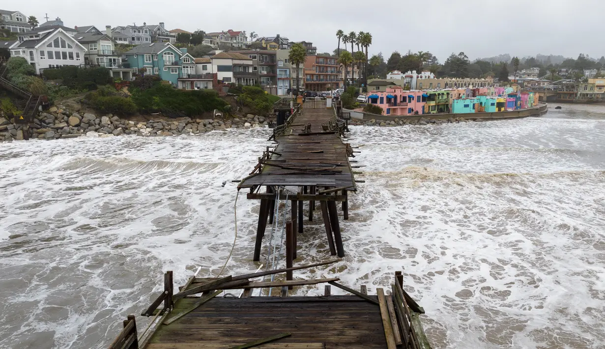 Pemandangan udara menunjukkan dermaga yang rusak terbelah di Capitola, California, pada 9 Januari 2023. Badai besar yang disebut "badai bom" oleh ahli meteorologi telah tiba dan diperkirakan akan menyebabkan banjir yang meluas di seluruh negara bagian. (AFP/Josh Edelson)