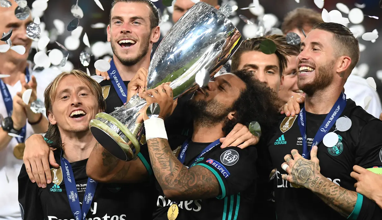 Bek Real Madrid, Marcelo, mencium trofi Piala Super Eropa usai mengalahkan Manchester United di Stadion Philip II, Skopje, Selasa (8/8/2017). Ini merupakan gelar Piala Super Eropa keempat bagi Real Madrid. (AFP/Robert Atanasovski)