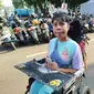 Yohana Felisitas (38), wanita difabel ini hanya bisa menyaksikan Misa Akbar Paus Fransiskus lewat layar ponsel meski berada di kawasan GBK, Senayan, Jakarta. Sebab dia tidak memiliki gelang khusus untuk masuk ke dalam stadion. (Liputan6.com/Ady Anugrahadi)