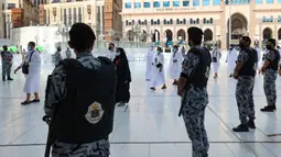 Pasukan keamanan Arab Saudi berjaga saat jemaah haji pertama pada awal musim haji tiba di Masjidil Haram, Arab Saudi, Sabtu (17/7/2021). Jumlah jemaah yang akan melaksanakan ibadah haji tahun ini sebanyak 60 ribu. (FAYEZ NURELDINE/AFP)