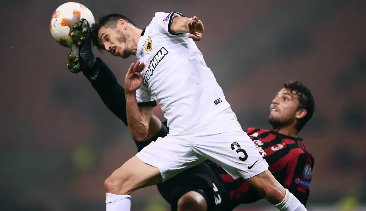Gelandang AC Milan, Manuel Locatelli, berebut bola dengan bek AEK Athens, Helder Lopes, pada laga Liga Europa di Stadion San Siro, Milan,  Kamis (19/10/2017). AC Milan bermain imbang 0-0 dengan AEK Athens. (AFP/Marco Bertorello)