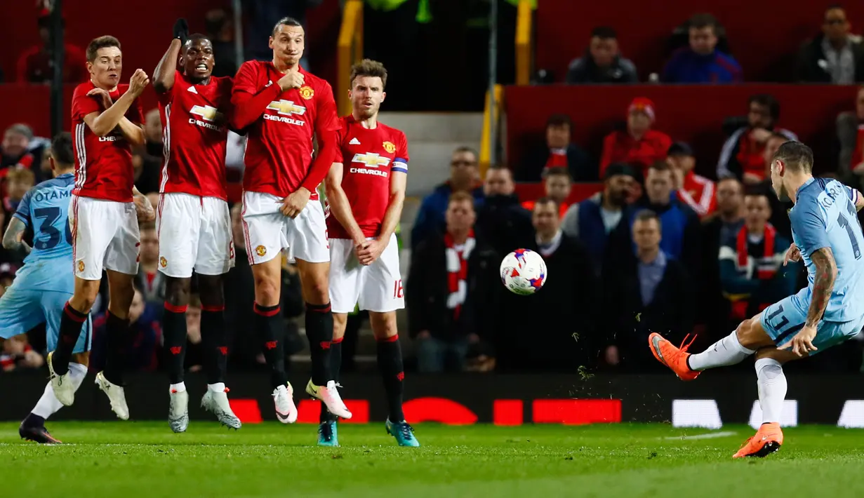 Tendangan bebas pemain City, Aleksandar Kolarov yang dihadang para pemain MU pada pertandingan Piala Liga Inggris di Stadion Old Trafford, Manchester, Inggris (26/10). (Reuters/Jason Cairnduff)