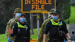 Petugas kepolisian dan tentara berpatroli di jalur lari yang populer di Melbourne, Selasa (4/8/2020). Negara bagian Victoria di Australia, khususnya ibu kota Melbourne mengumumkan status darurat bencana COVID-19 pada Minggu (2/8) waktu setempat. (William WEST / AFP)