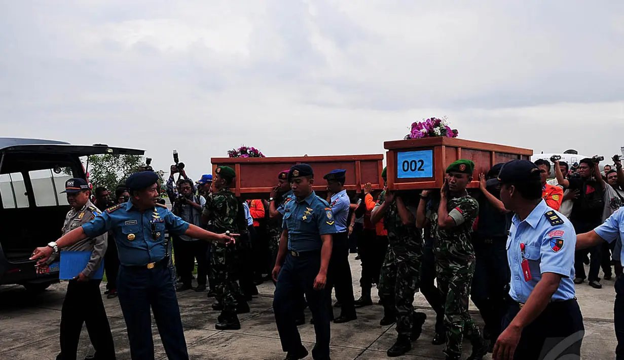 Sejumlah petugas membawa peti jenazah ke dalam mobil ambulans menuju Rumah Sakit Bhayangkara Polda Jatim, Rabu (31/12/2014). (Liputan6.com/Johan Tallo)