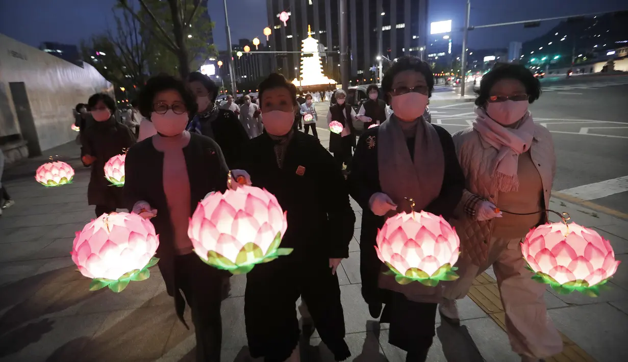 Umat mengenakan masker saat merayakan ulang tahun Buddha di Gwanghwamun Plaza, Seoul, Korea Selatan, Kamis (30/4/2020). Ulang tahun Buddha kali ini dirayakan di tengah pandemi virus corona COVID-19. (AP Photo/Ahn Young-joon)