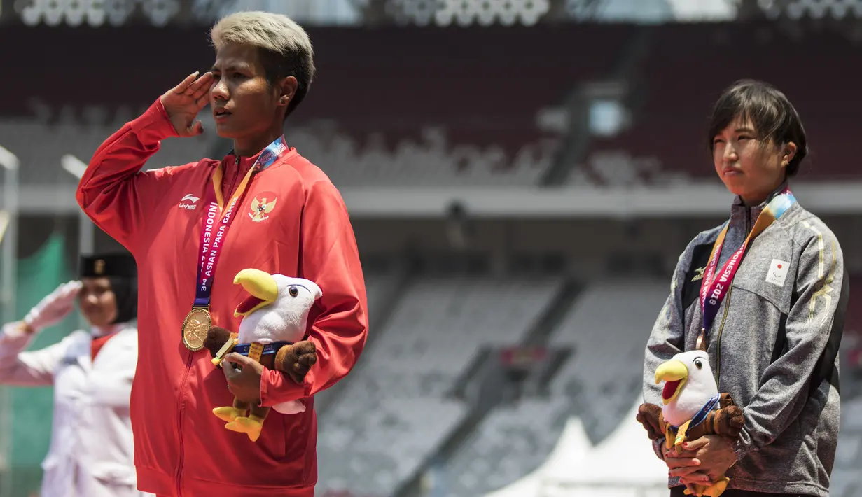 Atlet lompat jauh Indonesia, Rica Oktavia, hormat bendera saat seremoni usai meraih medali emas Asian Para Games 2018 di SUGBK, Jakarta, Senin (8/10/2018). (Bola.com/Vitalis Yogi Trisna)