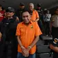 Polisi bersenjata menggiring tersangka dugaan pengaturan skor di Polda Metro Jaya, Jakarta, Rabu (10/4). Sebelum diserahkan ke kejaksaan, polisi lebih dulu mengecek kesehatan para tersangka di Biddokes Polda Metro Jaya. (merdeka.com/Imam Buhori)