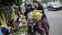 Seorang wanita usai membeli kulit ketupat di Pasar Palmerah, Jakarta, Senin (2/6/2019). Peningkatan drastis dikarenakan banyak warga yang ingin membuat masakan khas Lebaran seperti Opor Ayam yang selalu ditemani ketupat sebagai pengganti lontong. (Liputan6.com/Faizal Fanai)