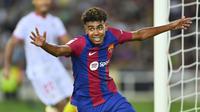 Pemain Barcelona, Lamine Yamal melakukan selebrasi setelah pemain Sevilla, Sergio Ramos mencetak gol bunuh diri pada laga lanjutan Liga Spanyol 2023/2024 melawan Barcelona di Estadi Olimpic Lluis Companys, Barcelona, Spanyol, Sabtu (30/09/2023) dini hari WIB. Gol bunuh diri Ramos berawal dari umpan silang Lamine Yamal. (AFP/Pau Barrena)