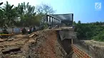 Pengendara roda dua melintasi jalan longsornya tepian jembatan Cipamingkis Cibarusah, Kab Bekasi, Jawa Barat (15/7). Sudah lebih empat bulan jembatan tersebut tertutup bagi kendaraan roda empat. (Merdeka.com/Arie Basuki)