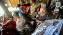 Para perajin menyelesaikan pembuatan batik tulis di Tie Poek Batik, Trenggalek, Jawa Timur, Sabtu (2/9/2023). Batik tulis corak Trenggalek didominasi bunga cengkeh. (merdeka.com/Arie Basuki)