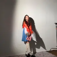 Di sini, IU mengenakan atasan merah transparan dari bahan organza dengan detail ruffle dengan tennis skirt dan mary-jane shoes yang disempurnakan dengan kaus kaki panjang selutut. Foto: Instagram @dlwlrma.