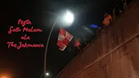 Beberapa pemuda The Jakmania bernyanyi dan mengibarkan bendera. (Bola.com/Nicklas Hanoatubun)